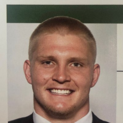 a man wearing a suit and tie smiling at the camera