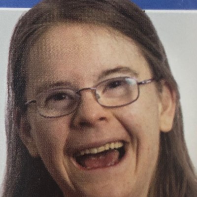 a person wearing glasses and smiling at the camera